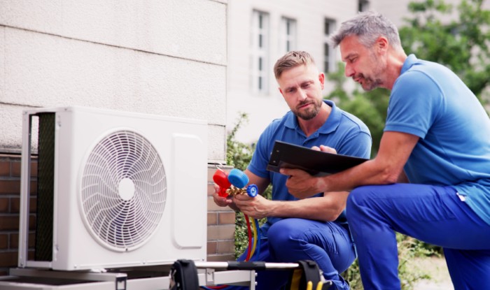 HVAC technicians reviewing an outdoor air conditioning unit in Layton, UT