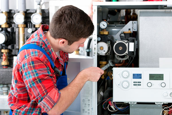 HVAC technician inspecting an indoor heating system in Layton, UT