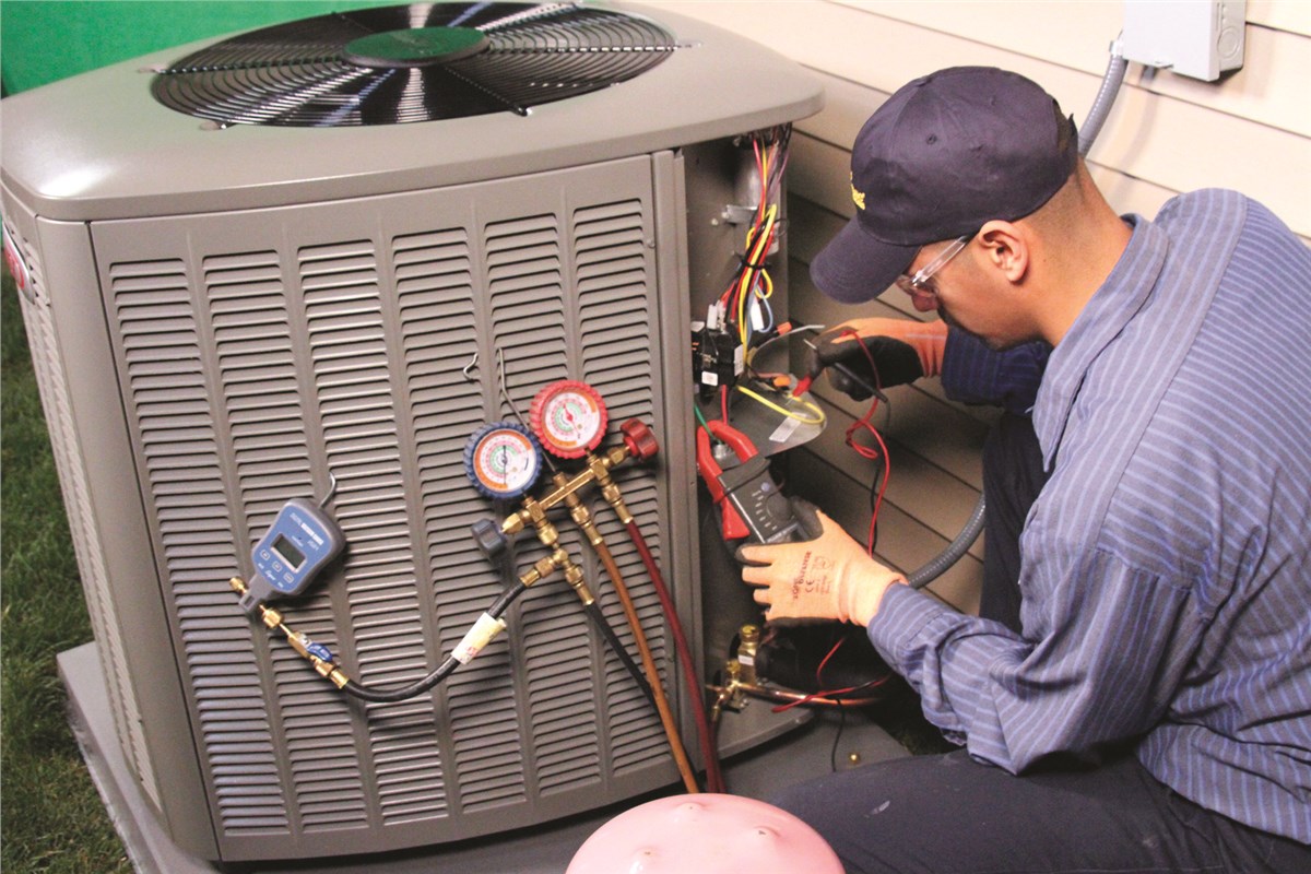HVAC technician testing an outdoor air conditioning unit in Layton