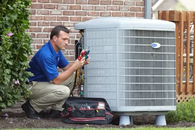 HVAC technician inspecting an outdoor air conditioning unit in Layton, UT